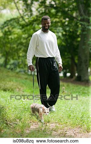 Stock Photography - Man walking a cat. Fotosearch