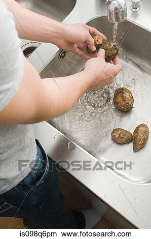 Man washing potatoes View Large Photo Image Picture - Man washing potatoes. Fotosearch