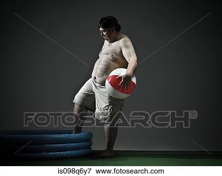 Man with beach ball and paddling pool View Large Photo Image Stock Photo - Man with beach ball and paddling pool. Fotosearch
