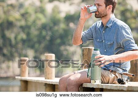 Man with fishing rod and hot drink View Large Photo Image Stock Image - Man with fishing rod and hot drink. Fotosearch