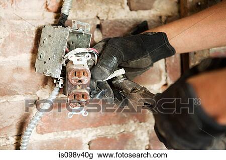Man working on electric socket by brick wall View Large Photo Image Stock Image - Man working on electric socket by brick wall. Fotosearch