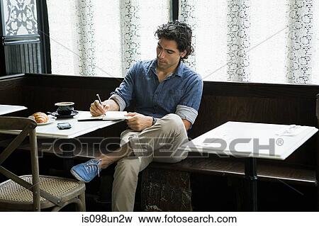 Man writing in coffee shop View Large Photo Image Stock Photo - Man writing in coffee shop. Fotosearch