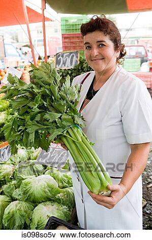 Market trader with celery View Large Photo Image Stock Photo - Market trader with celery. Fotosearch