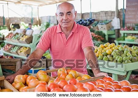 Stock Photograph - Market trader with tomatoes. Fotosearch