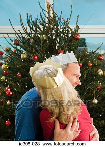 Stock Photo - Mature couple hugging at christmas. Fotosearch