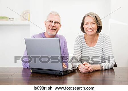 Mature man and woman using a laptop View Large Photo Image Stock Image - Mature man and woman using a laptop. Fotosearch