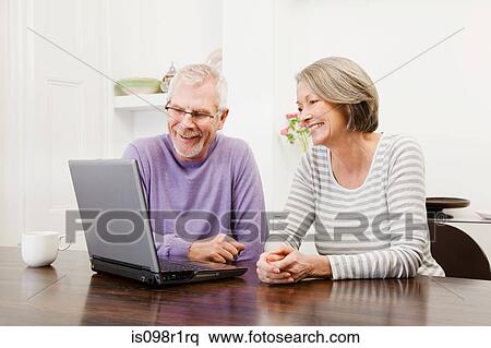 Stock Photography - Mature man and woman using a laptop. Fotosearch