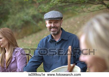 Stock Image - Mature man at outdoor dinner. Fotosearch