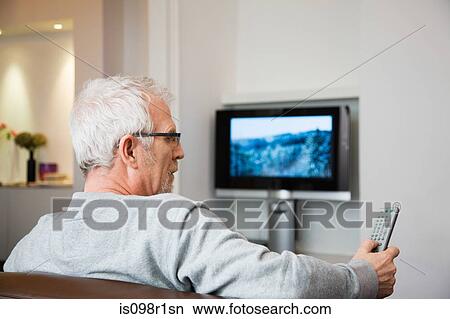 Mature man watching television View Large Photo Image Picture - Mature man watching television. Fotosearch