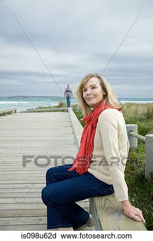 Stock Image - Mature woman at the coast. Fotosearch