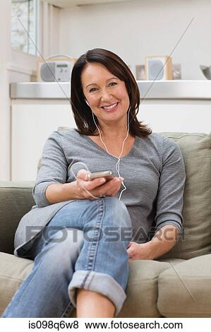 Stock Photo - Mature woman listening to an mp3 player. Fotosearch