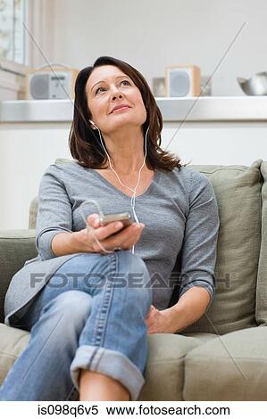 Mature woman listening to an mp3 player View Large Photo Image Stock Photography - Mature woman listening to an mp3 player. Fotosearch
