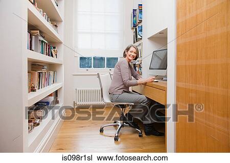 Stock Image - Mature woman using a computer. Fotosearch