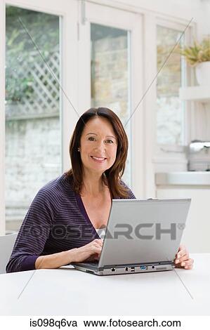 Mature woman using a laptop View Large Photo Image Stock Image - Mature woman using a laptop. Fotosearch