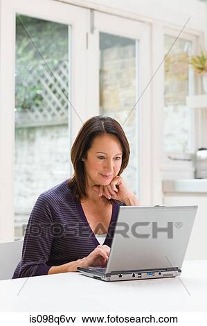 Stock Photo - Mature woman using a laptop. Fotosearch