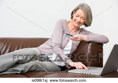 Stock Image - Mature woman using internet banking. Fotosearch