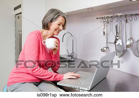 Mature woman using laptop View Large Photo Image Stock Photography - Mature woman using laptop. Fotosearch