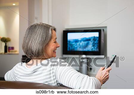 Stock Image - Mature woman watching television. Fotosearch