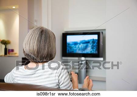 Stock Photography - Mature woman watching television. Fotosearch