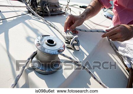 Mid adult man on board yacht holding rope View Large Photo Image Stock Photograph - Mid adult man on board yacht holding rope. Fotosearch