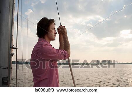 Mid adult man on board yacht, looking at view View Large Photo Image Stock Image - Mid adult man on board yacht, looking at view. Fotosearch