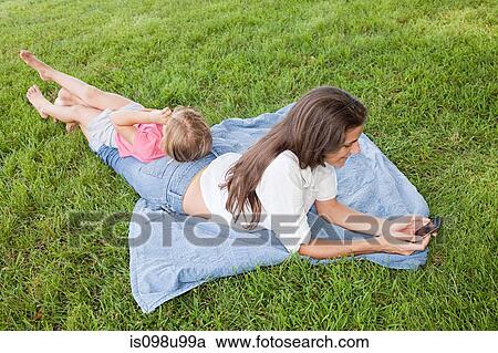Mother and daughter lying on grass View Large Photo Image Stock Image - Mother and daughter lying on grass. Fotosearch
