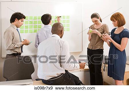 Office workers writing ideas on adhesive notes View Large Photo Image Stock Photo - Office workers writing ideas on adhesive notes. Fotosearch