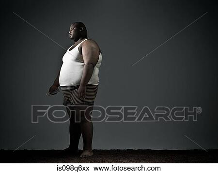 Stock Photo - Overweight man in underwear watching tv. Fotosearch