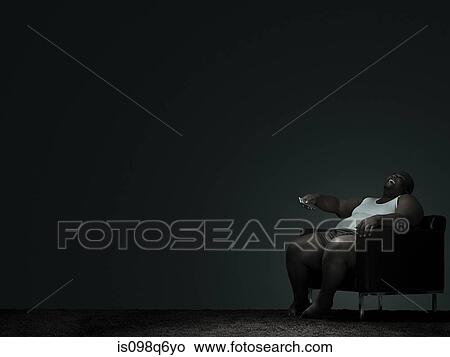 Picture - Overweight man watching television. Fotosearch