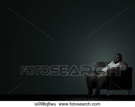 Overweight man watching television View Large Photo Image Stock Photograph - Overweight man watching television. Fotosearch
