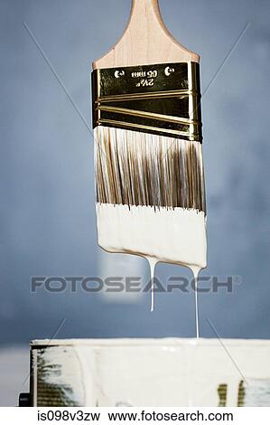 Stock Photo - Paintbrush with white paint dripping. Fotosearch