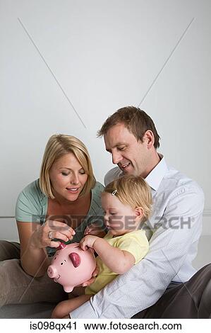 Stock Image - Parents and baby with piggy bank. Fotosearch