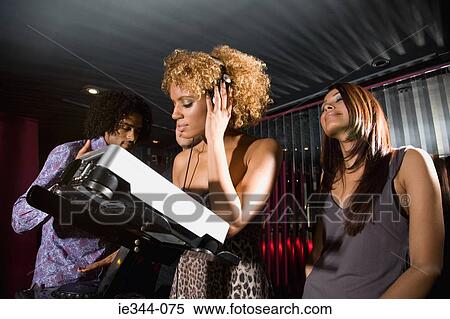 Stock Photography - People around a dj in a nightclub. Fotosearch