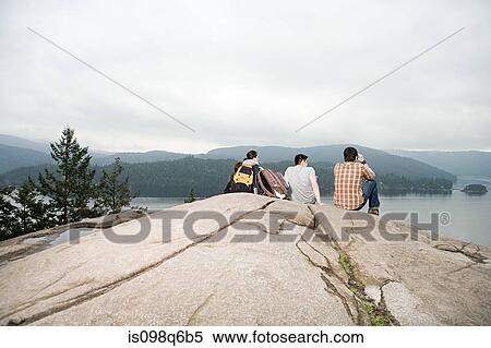 People on rock by a lake View Large Photo Image Stock Photography - People on rock by a lake. Fotosearch