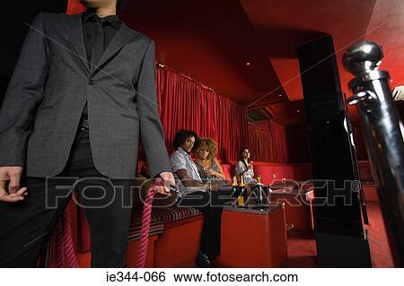 Stock Photograph - People sat in a vip area of a nightclub. Fotosearch