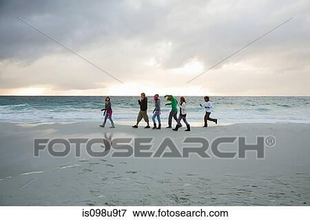 People walking on beach View Large Photo Image Stock Photo - People walking on beach. Fotosearch