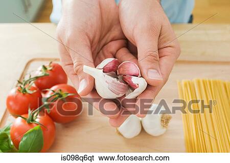 Stock Photograph - Person holding garlic. Fotosearch