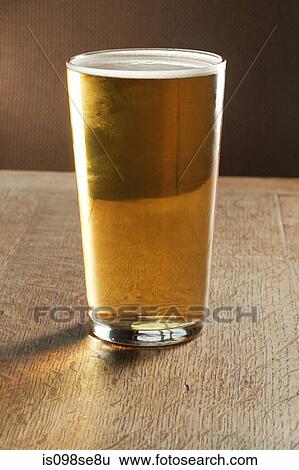 Pint of beer on table View Large Photo Image Stock Photograph - Pint of beer on table. Fotosearch