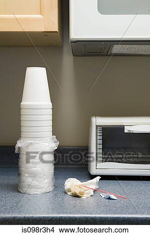 Picture - Polystyrene cups and rubbish on office kitchen counter. Fotosearch