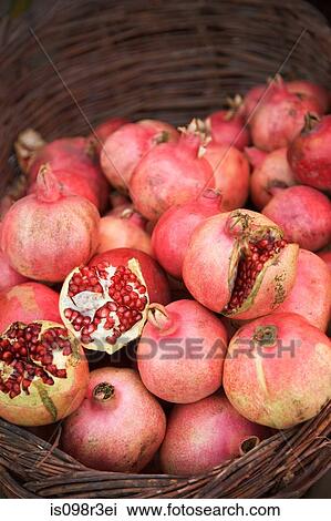 Stock Image - Pomegranate in a basket at market stall. Fotosearch
