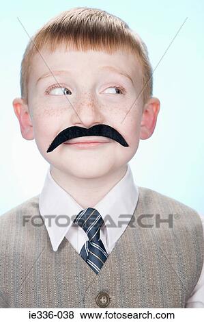 Stock Photo - Portrait of a boy wearing a fake moustache. Fotosearch
