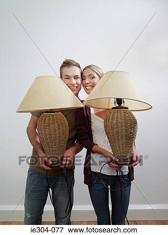 Portrait of a couple holding lamps View Large Photo Image Stock Photo - Portrait of a couple holding lamps. Fotosearch