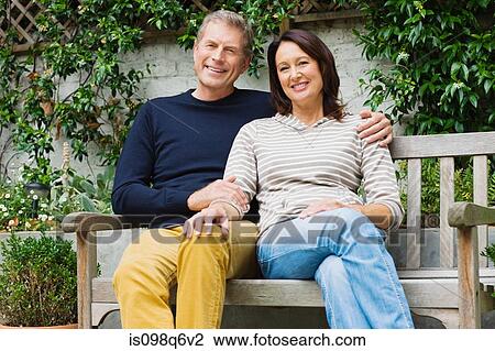 Portrait of a couple sat on a bench View Large Photo Image Stock Image - Portrait of a couple sat on a bench. Fotosearch