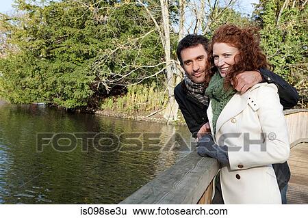 Stock Photograph - Portrait of a couple standing on a bridge. Fotosearch