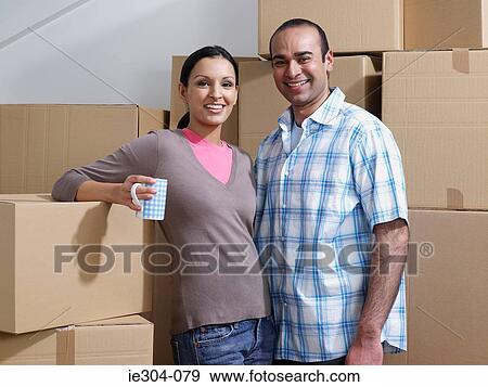 Portrait of a couple taking a break from moving house View Large Photo Image Stock Photo - Portrait of a couple taking a break from moving house. Fotosearch