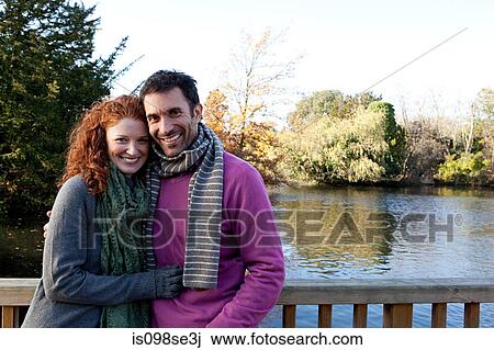 Stock Image - Portrait of a happy couple on a river bridge. Fotosearch