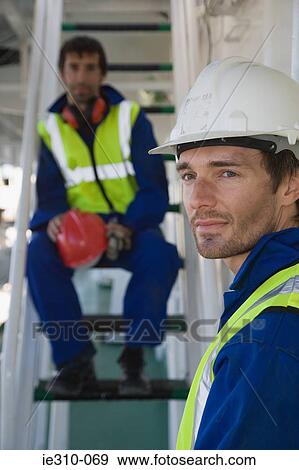 Stock Photo - Portrait of a manual worker wearing a hard hat. Fotosearch