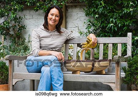 Portrait of a mature woman sat on a bench View Large Photo Image Stock Image - Portrait of a mature woman sat on a bench. Fotosearch