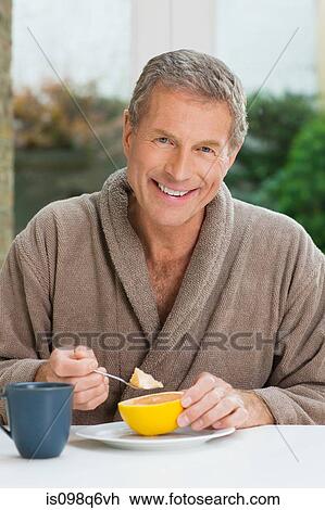 Stock Image - Portrait of a senior man having breakfast. Fotosearch