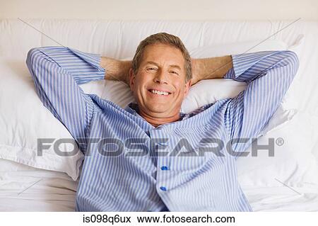 Stock Photo - Portrait of a senior man lying in bed. Fotosearch